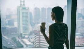 Woman looking out of a large window.