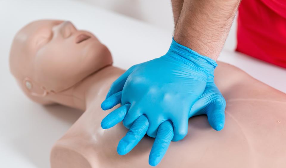 CPR on a manikin with blue gloves