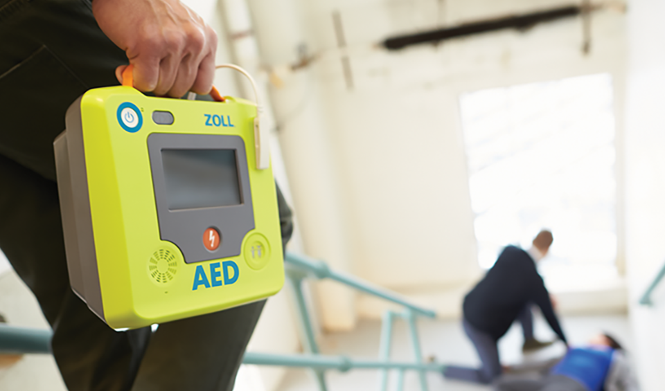 A person bringing a ZOLL Automated External Defibrillator (AED) to the scene of a cardiac emergency