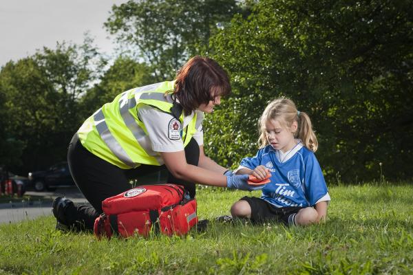 A female SJA volunteer helping a young girl with a group soccer injury.