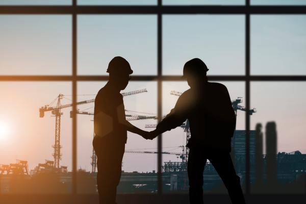 Industry. Silhouette of two men shaking hands.