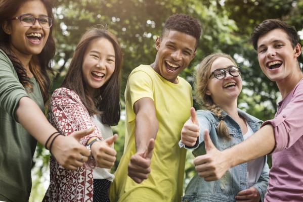 Group of youth smiling and giving thumbs up.