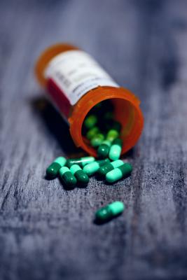 Photo of prescription bottle of pills spilled out on table. Photo by Sharon McCutcheon on Unsplash