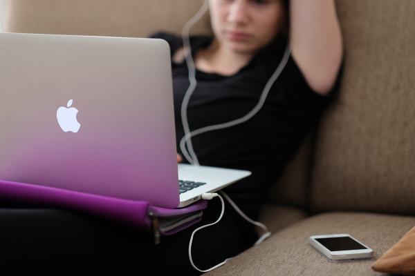 Teen using a MacBook on a couch. Photo by Steinar Engeland on Unsplash