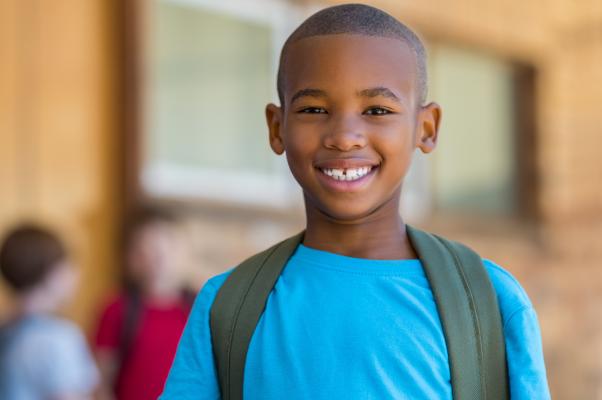 African American Boy with blue shirt and backpack