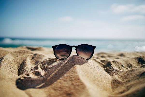 Sunglasses on sand at beach. Photo by Ethan Robertson on Unsplash