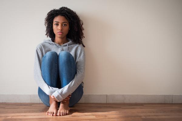 Teen sitting on floor in mental distress