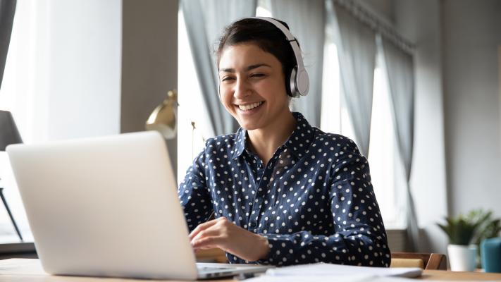 Woman on laptop with headphones