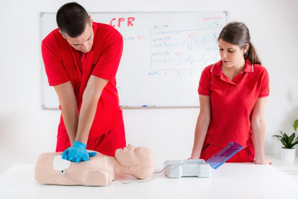 2 people in red shirts learning CPR