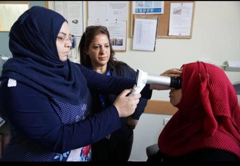 Woman checking patient's eye sight