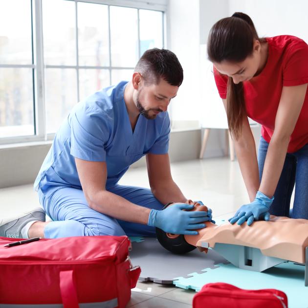 Man performing CPR with female instructor
