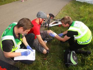 Patient being helped by SJA Medical First Responders after falling from his bike.